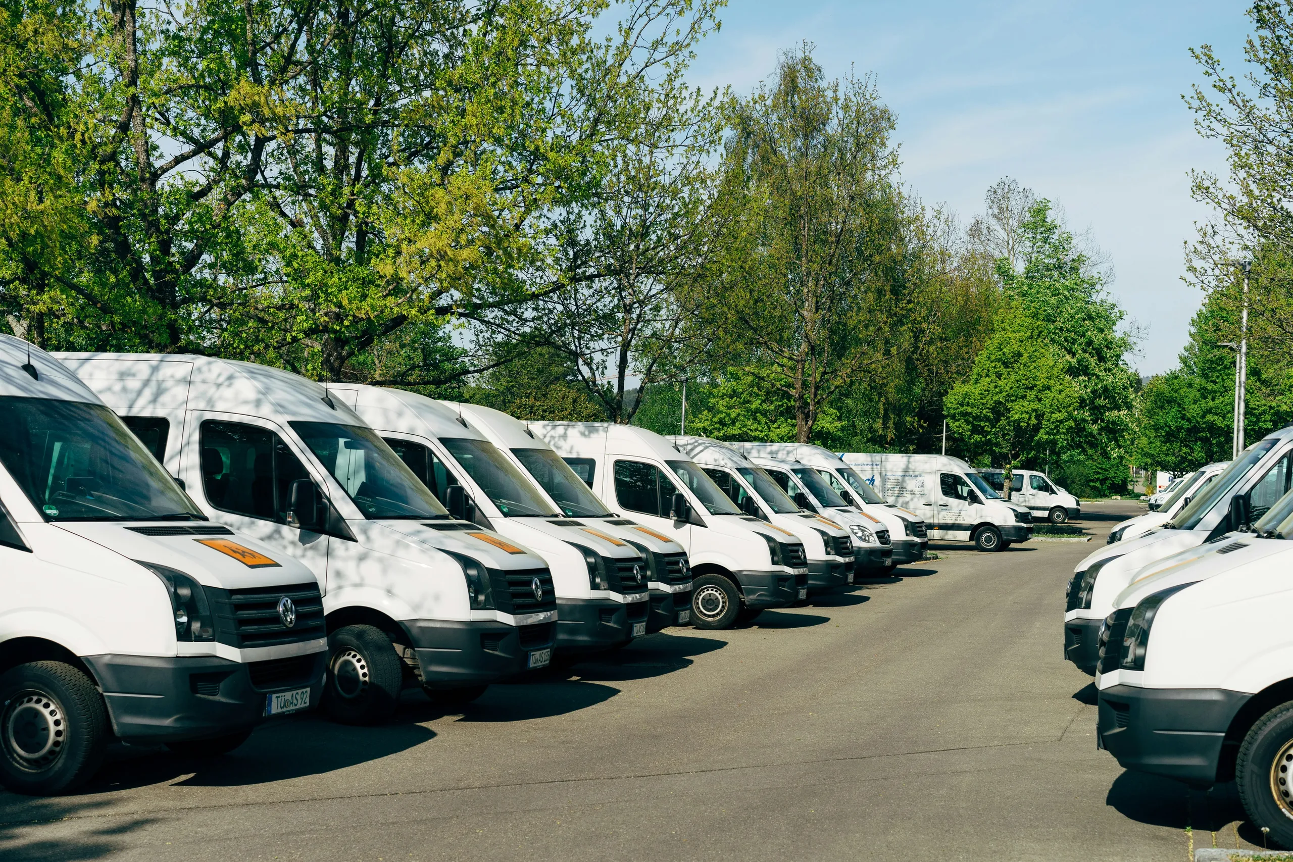 Flota białych busów zaparkowanych w rzędzie
